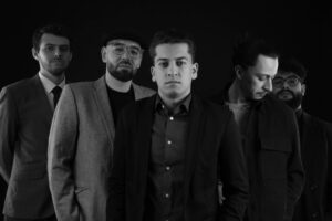 Musikgruppe vor schwarzem Hintergrund